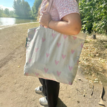 Afbeelding in Gallery-weergave laden, Duurzame tas gerecycled katoen met roze hartjes sfeerfoto strand