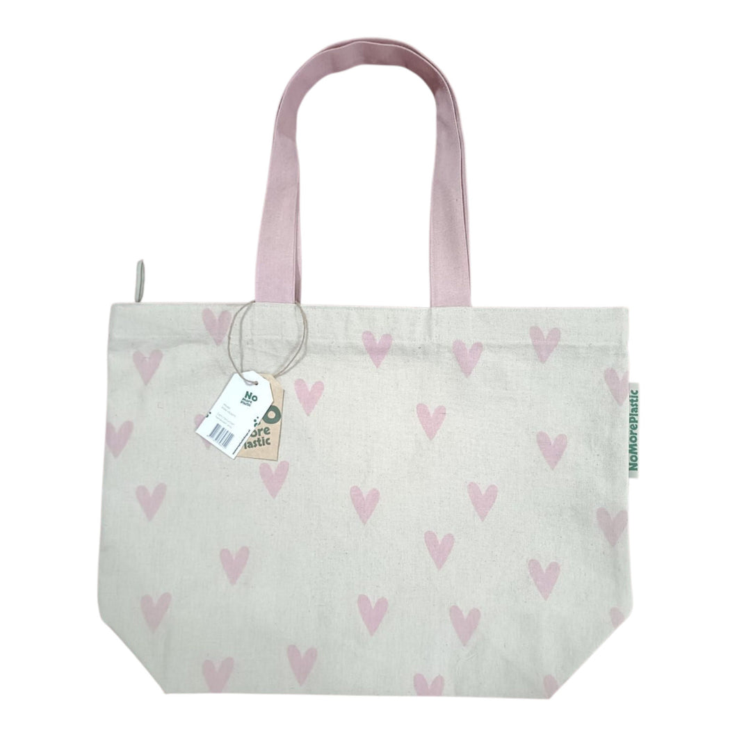 Duurzame tas van gerecyled katoen. De tas met lange roze hengsels heeft een print van kleine roze hartjes